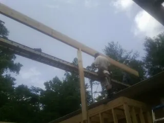 Carpenter setting a ridge beam over a new addition frame — Ice Dam Removal by Roofing Brothers in New Galilee