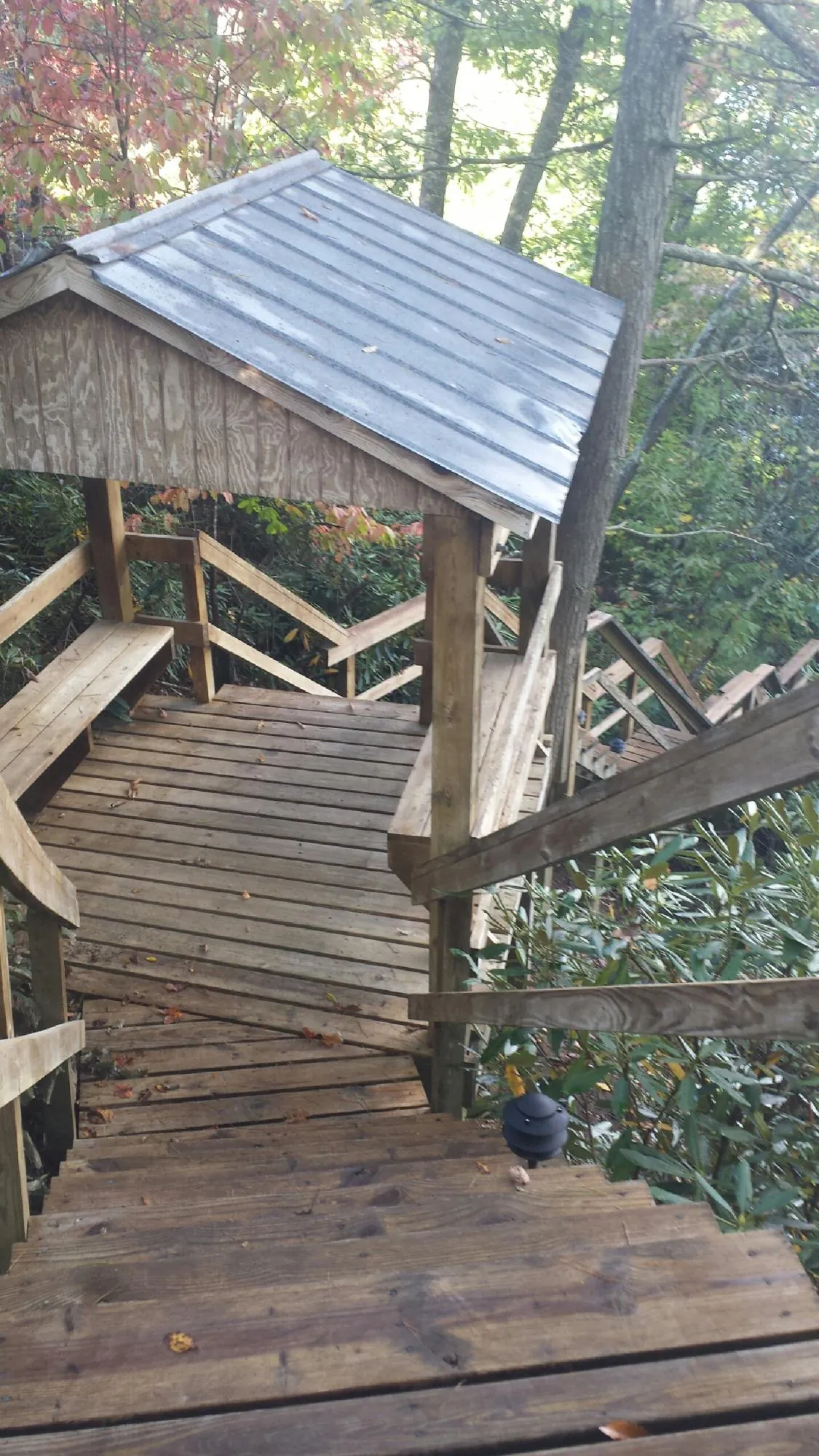 Metal roofed shelter over wooden steps on a wooded walkway — Skylight Repair & Installation work by our crew in New Galilee