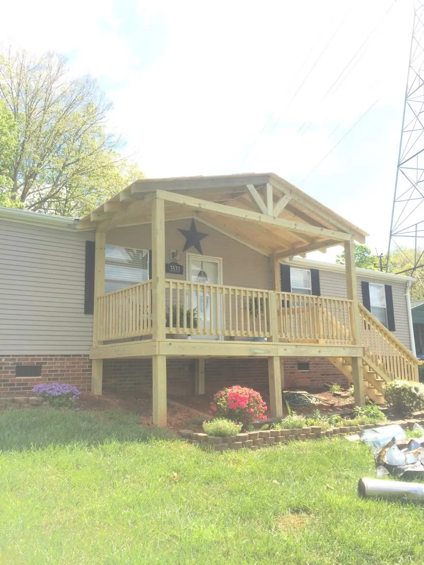 New gabled porch roof and deck railing added to a ranch home in New Galilee